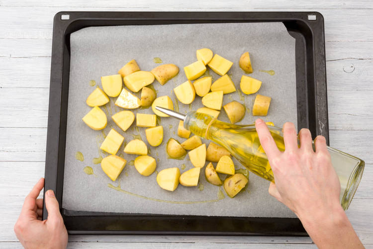 Verdeel de aardappelen over een ovenschaal en besprenkel met ⅓ van de olijfolie.