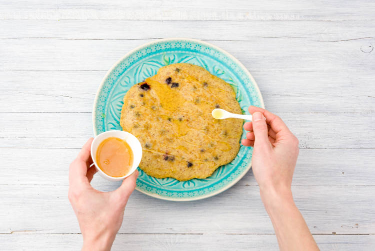 Verdeel de pannenkoeken over de borden en schenk de honing erover.