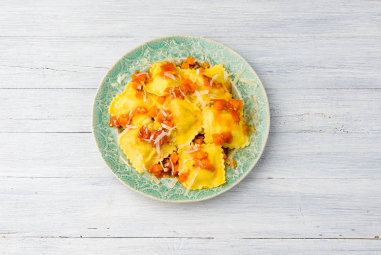 Verdeel de ravioli en de saus over de borden.