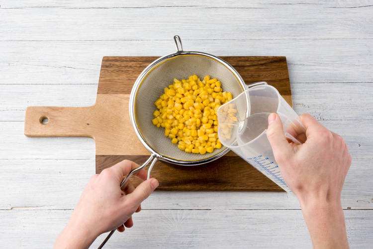 Zuckermais in Sieb abgießen