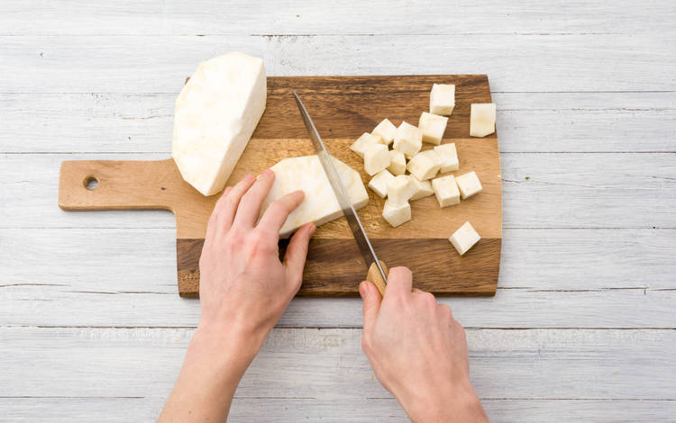 Schil de aardappelen en knolselderij en snijd in parten.