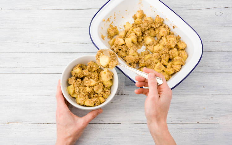 Verdeel de warme appel-kruimel over diepe kommen en verdeel de Griekse yoghurt.