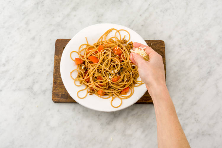 Verdeel de spaghetti over de borden.