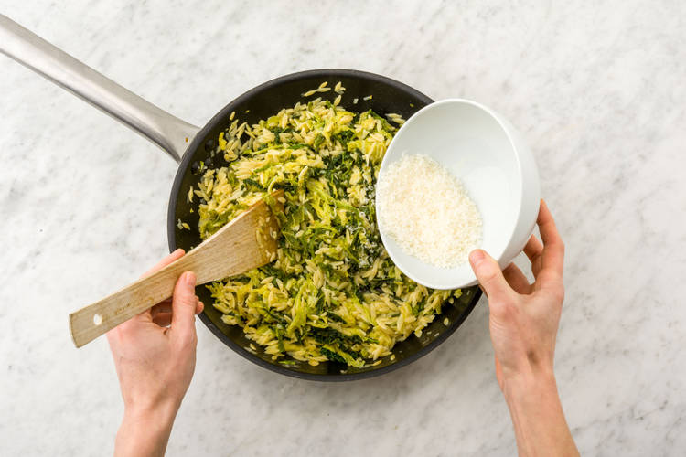 Roer de helft van de pecorino door de orzo.