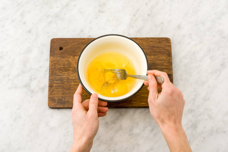 Kluts de eieren in een kom met een vork los.