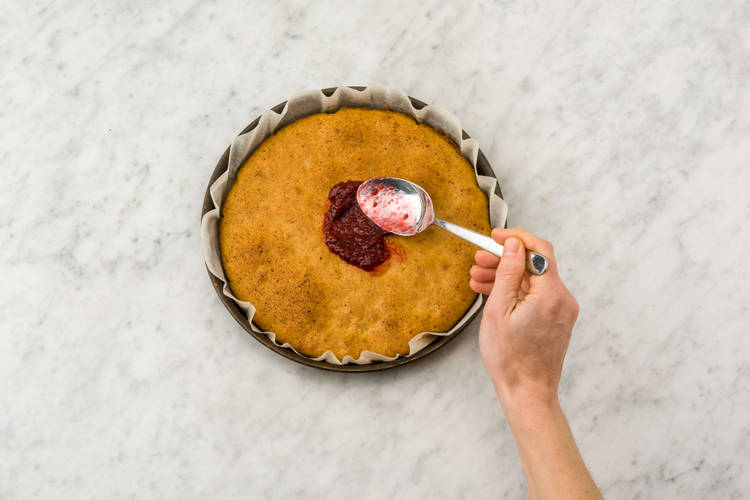 Haal de koek uit de oven en besmeer met de jam.