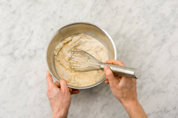 Meng de pannenkoekenmix met de helft van de melk in een beslagkom.