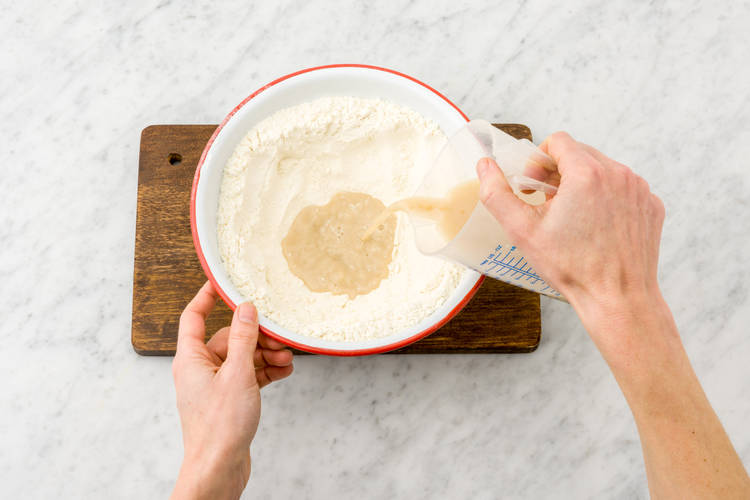 Pour the yeast mixture into the flour well