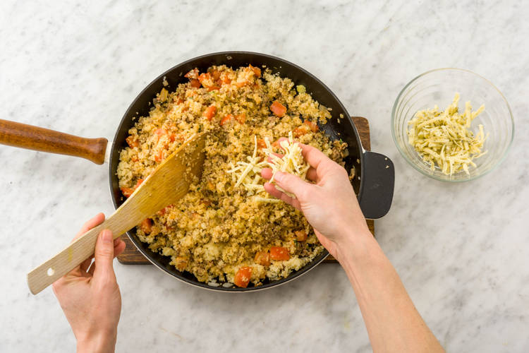 Roerbak de tomaat, de bosui, komijnekaas en de bulgur.