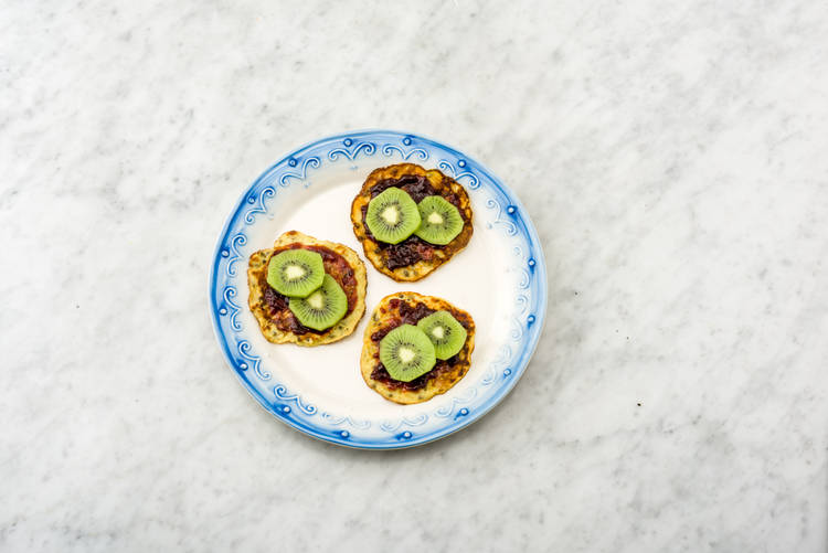 Besmeer met de kersenjam en beleg met de kiwi.