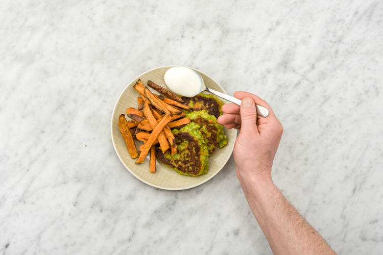 Serveer de broccoliburgers met de bataatfrietjes en de yoghurt.