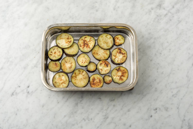 Houd de aubergine warm in een ovenschaal.