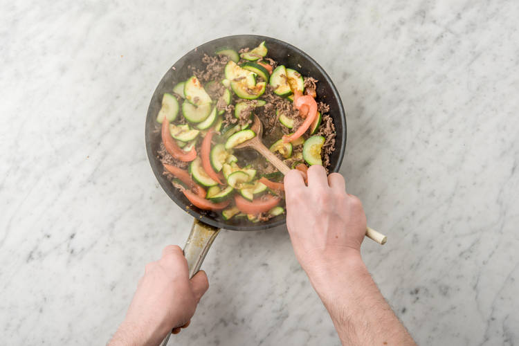 Bak de courgette, het gehakt en de tomaat.