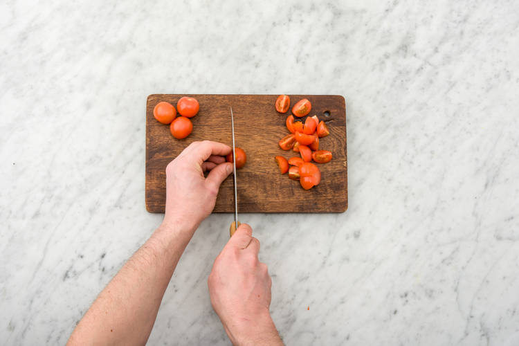 Quarter the cherry tomatoes