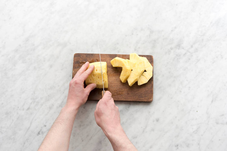 Snijd de ananas in halve plakken.