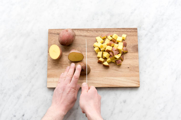 Snijd de aardappelen in blokjes.