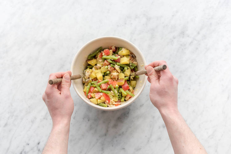 Voeg de dressing toe aan de salade.