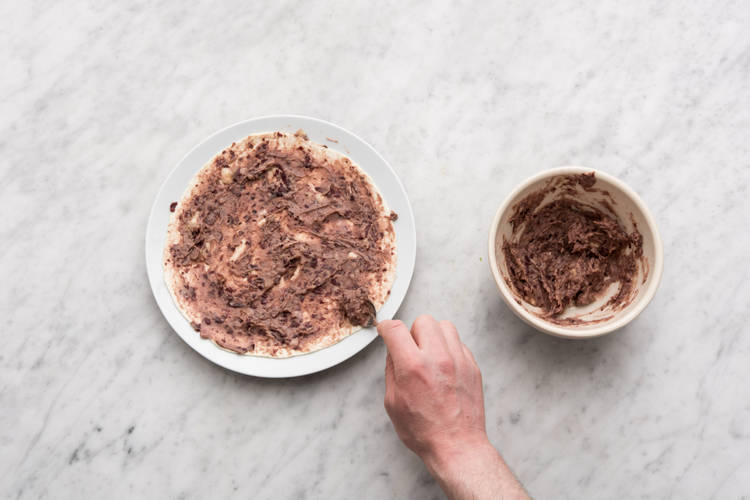 Besmeer de tortilla met de mole.
