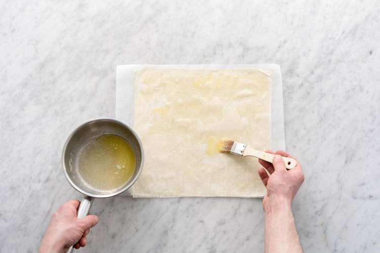 Teig mit Butter bestreichen