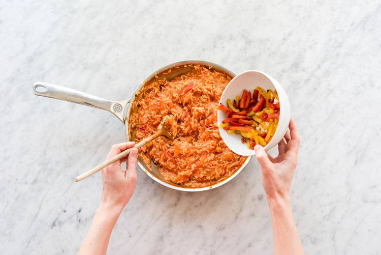 Roer de paprika door de rijst.