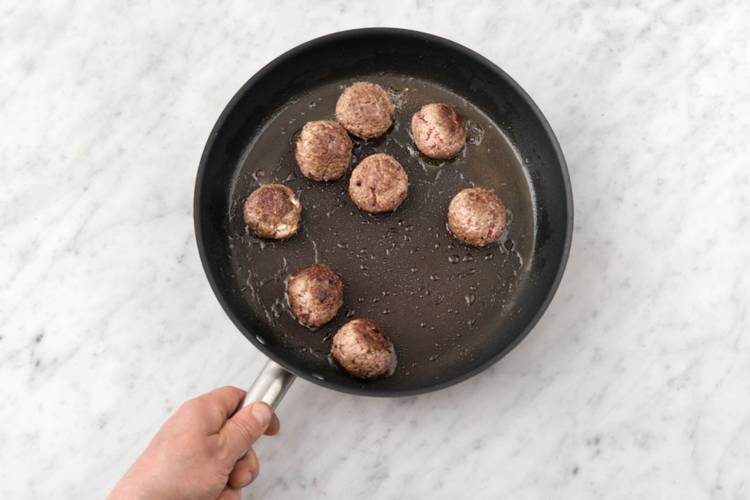 Boil the pasta and sear the meatballs