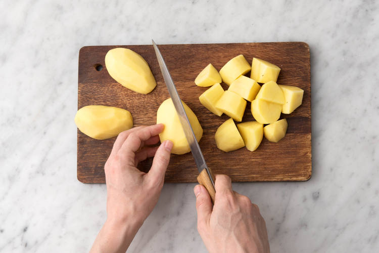 Snijd de aardappelen in kwarten.