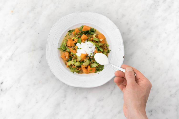 Garneer het gerecht met koriander en yoghurt