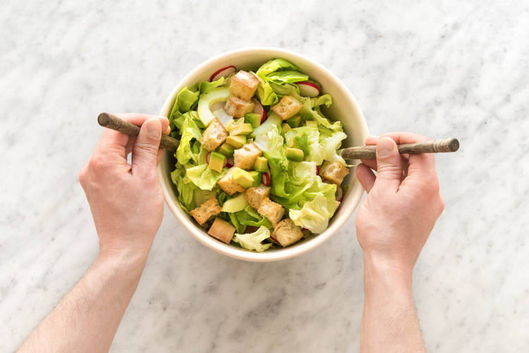 Voeg de dressing toe aan de salade.
