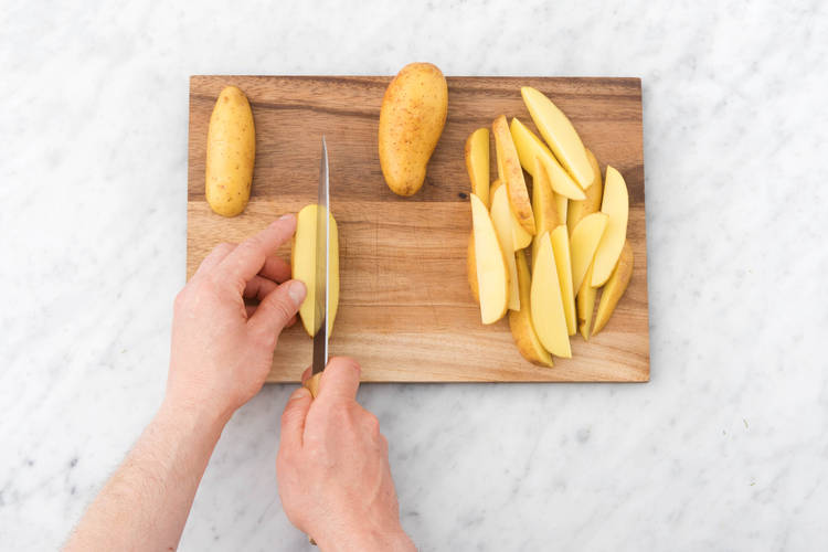 Snijd de aardappelen in parten.