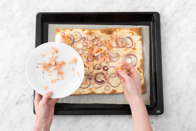 Lachslocken auf dem Flammkuchen verteilen