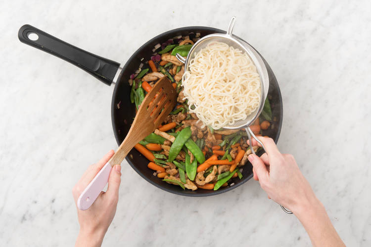 Voeg de noedels toe aan de wok of hapjespan met deksel en verhit nog in 1 minuut op hoog vuur