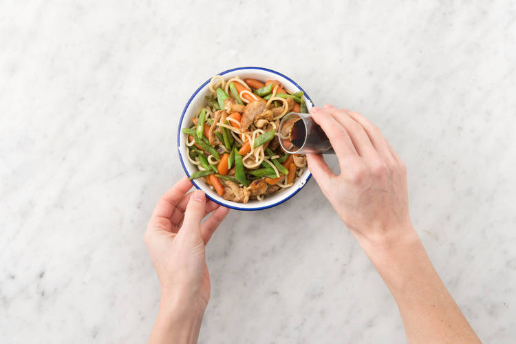 Verdeel het gerecht over de borden en breng op smaak met extra ketjap