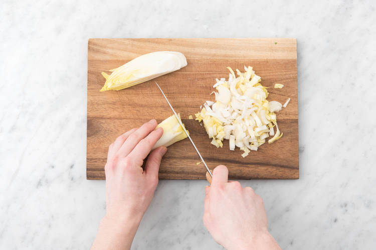 Couper le chicon en deux, retirer le cœur dur, puis la tailler en lanières de 1 cm.