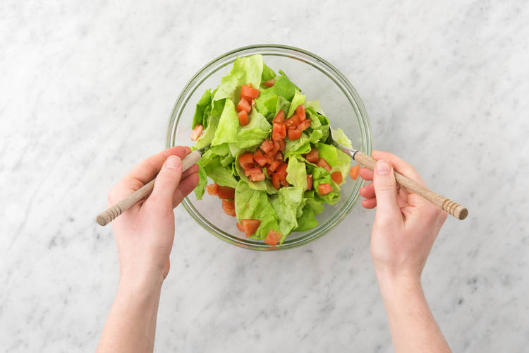 Dans un saladier, mélanger le reste de laitue et les morceaux de tomate avec l’huile d’olive vierge extra et le vinaigre de vin blanc.