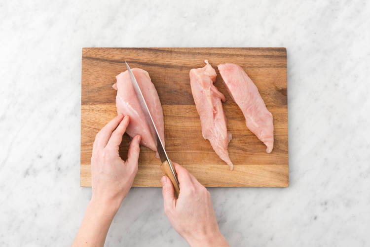 Couper le filet de poulet en deux dans le sens de la longueur et l'ajouter aussi sur la plaque