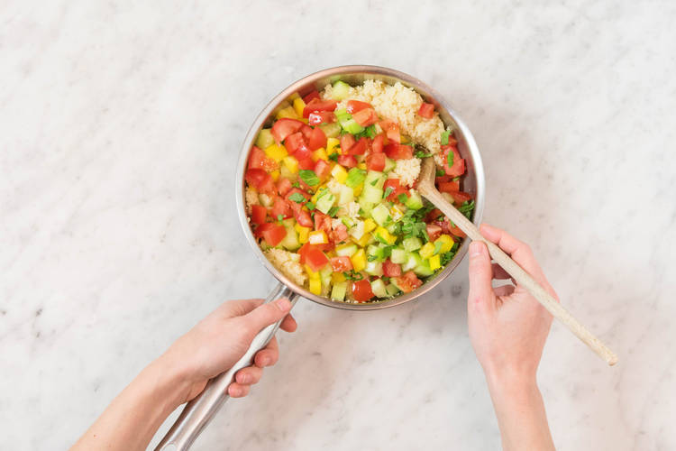Gurken- und Tomatenstücke sowie gehackte Minze vorsichtig unterheben