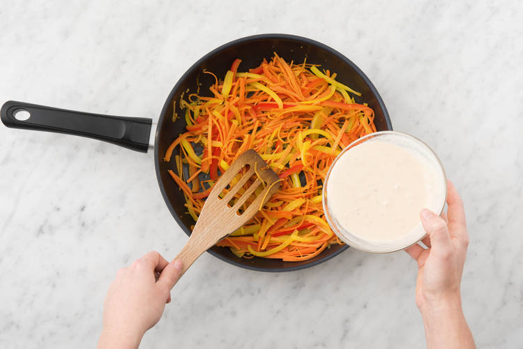 5	Ajouter le mélange de beurre de cacahuète et de coco au wok.