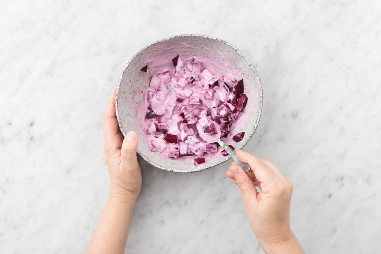 Bewaar het bietensap uit de verpakking apart en snijd vervolgens de rode biet in blokjes van 1 cm. Meng in een kom met 1 eetlepel yoghurt per persoon, de helft van de munt, 1 eetlepel limoensap per persoon en witte wijnazijn.
