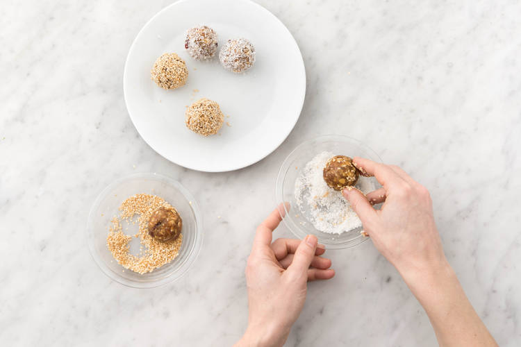 Bällchen mit Sesam und Kokos umfüllen