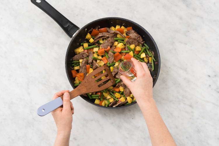 Kartoffelwürfel, Bohnen- und Paprikastücke und Gewürzmischung dazugeben