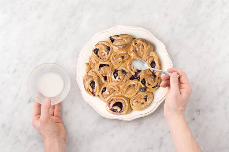 Zuckerguss über die Röllchen geben