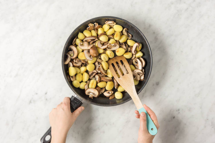 Champignons zu den Gnocchis geben