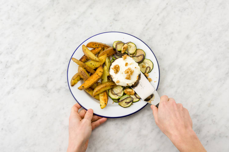 Servir les pommes de terre, les légumes et les portobellos sur les assiettes