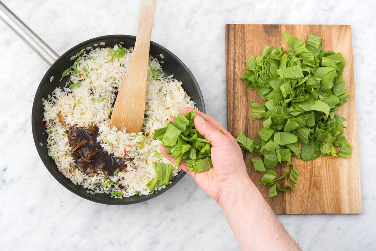 Ajoutez le riz, la sauce et les feuilles de l'am choi