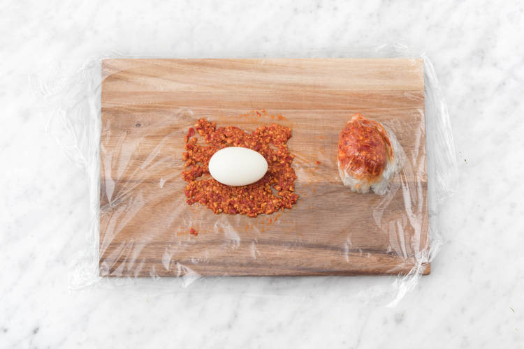 Posez l'oeuf sur une couche de sambal et fermez le film fraîcheur