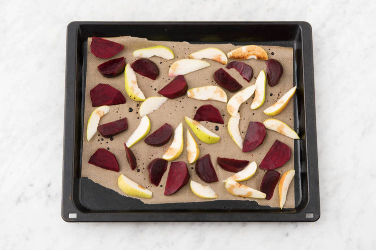 Répartir les morceaux de poire et betterave sur une plaque de cuisson recouverte de papier de cuisson.
