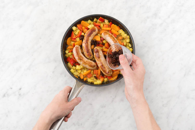 Ajouter les merguez et les raisins secs.