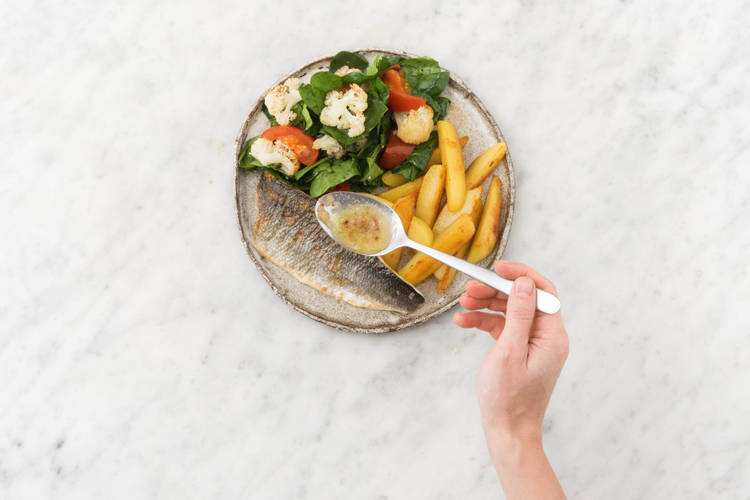 Servir la salade de chou-fleur et d’épinards ainsi que les pommes de terre sur les assiettes