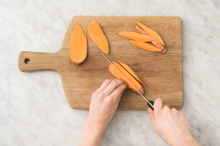 Zoete aardappel in grove frieten snijden