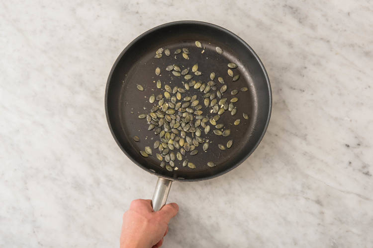 Faire cuire les raviolis et faire griller les graines de citrouille